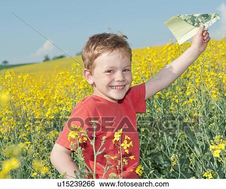 Boy playing with paper airplane in field View Large Photo Image Stock Photograph - Boy playing with paper airplane in field. Fotosearch