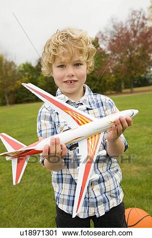 Boy playing with toy airplane outdoors View Large Photo Image Stock Image - Boy playing with toy airplane outdoors. Fotosearch
