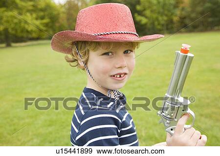 Boy playing with toy gun outdoors View Large Photo Image Stock Photo - Boy playing with toy gun outdoors. Fotosearch
