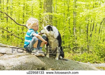 Boy sitting with dog in forest View Large Photo Image Stock Image - Boy sitting with dog in forest. Fotosearch