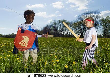 Stock Image - Boys playing dress up outdoors. Fotosearch