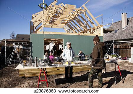 Stock Image - Builders talking on construction site. Fotosearch