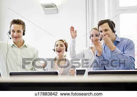 Stock Image - Business people cheering in headsets. Fotosearch