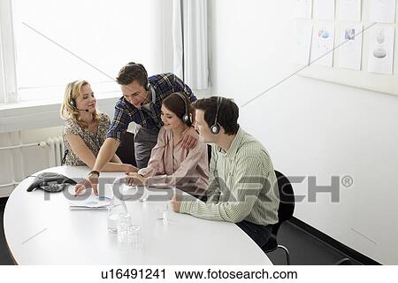 Stock Image - Business people in headsets in meeting. Fotosearch