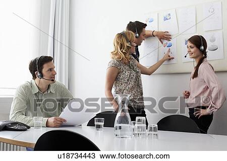 Stock Image - Business people in headsets in meeting. Fotosearch