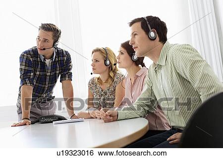 Business people in headsets in meeting View Large Photo Image Stock Photograph - Business people in headsets in meeting. Fotosearch