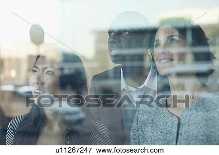 Stock Photo - Business people looking out window. Fotosearch