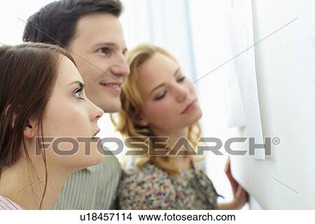 Picture - Business people reading signs in office. Fotosearch