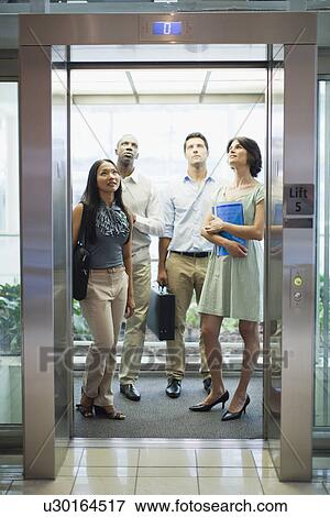 Stock Photo - Business people riding glass elevator. Fotosearch