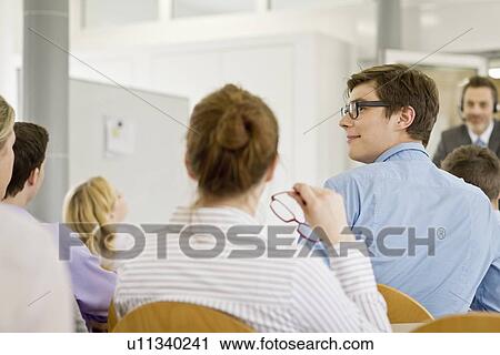Stock Image - Business people sitting in seminar. Fotosearch
