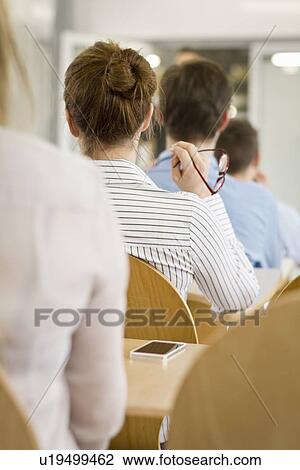 Stock Image - Business people sitting in seminar. Fotosearch