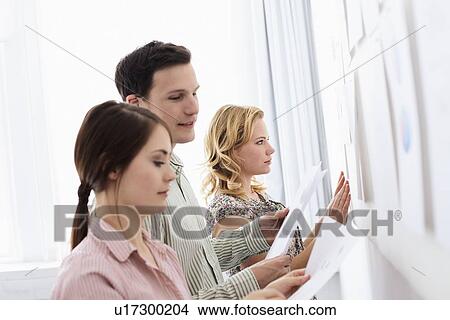 Picture - Business people tacking up signs. Fotosearch