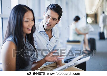 Stock Image - Business people talking in hallway. Fotosearch