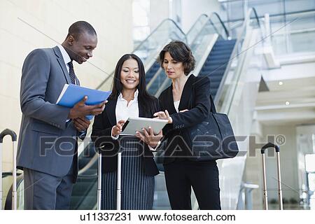 Stock Image - Business people talking in lobby. Fotosearch