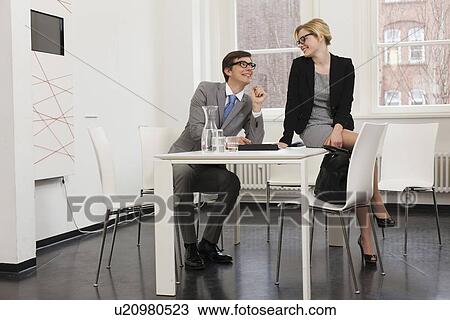 Stock Image - Business people talking in office. Fotosearch