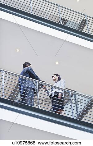 Stock Photo - Business people talking on balcony. Fotosearch