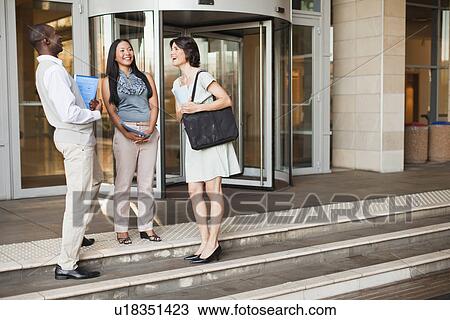 Stock Image - Business people talking on steps. Fotosearch