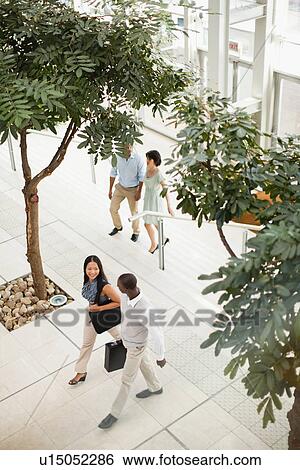 Stock Photograph - Business people walking in lobby. Fotosearch