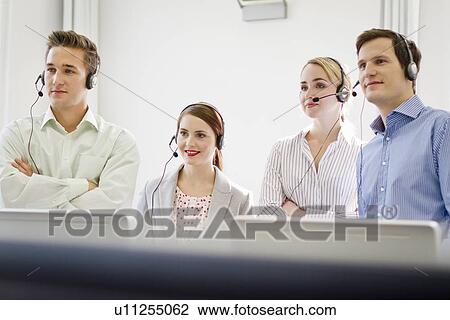 Stock Image - Business people working in headsets. Fotosearch