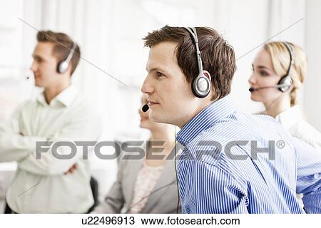 Stock Image - Business people working in headsets. Fotosearch