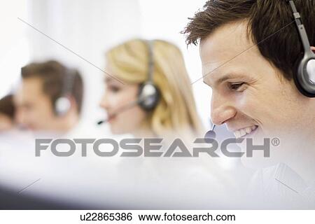 Business people working in headsets View Large Photo Image Stock Photograph - Business people working in headsets. Fotosearch