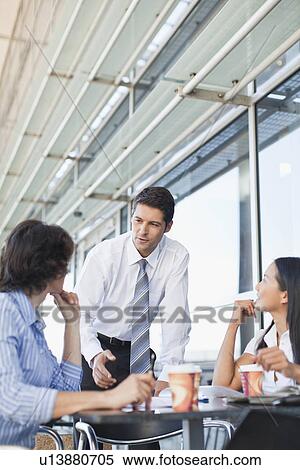 Stock Photography - Business people working together in cafe. Fotosearch