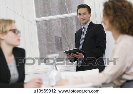 Stock Image - Businessman carrying tablet computer. Fotosearch