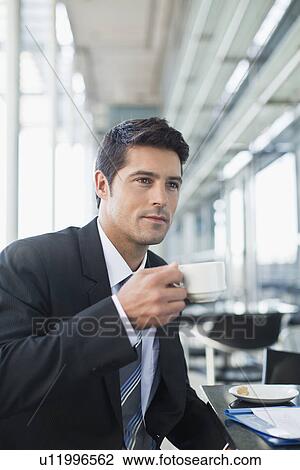 Stock Image - Businessman drinking coffee in cafe. Fotosearch