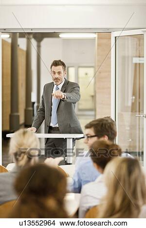 Businessman hosting seminar in office View Large Photo Image Picture - Businessman hosting seminar in office. Fotosearch