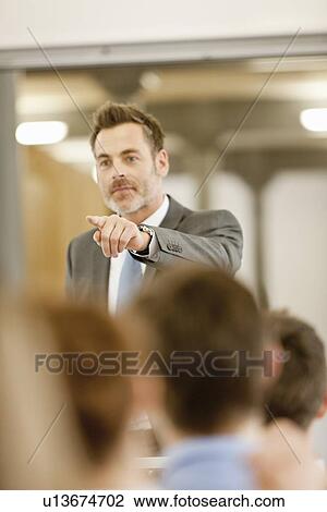 Businessman hosting seminar in office View Large Photo Image Stock Image - Businessman hosting seminar in office. Fotosearch