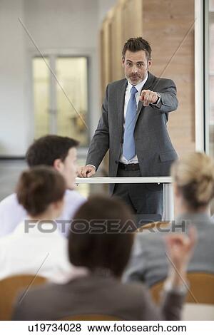 Stock Photo - Businessman hosting seminar in office. Fotosearch