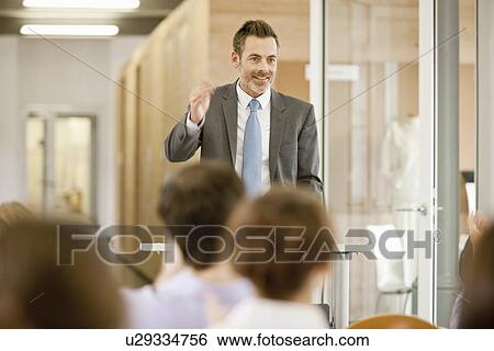 Stock Photograph - Businessman hosting seminar in office. Fotosearch