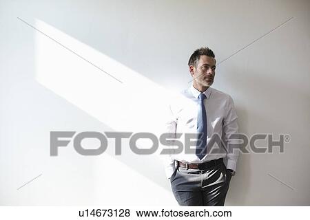 Businessman leaning against wall View Large Photo Image Stock Photo - Businessman leaning against wall. Fotosearch
