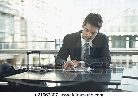 Stock Photo - Businessman making notes in cafe. Fotosearch