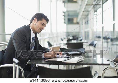 Businessman making notes in cafe View Large Photo Image Stock Photograph - Businessman making notes in cafe. Fotosearch