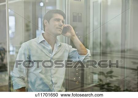 Businessman on cell phone in elevator View Large Photo Image Stock Image - Businessman on cell phone in elevator. Fotosearch