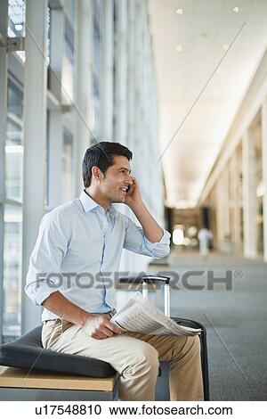 Stock Image - Businessman on cell phone in hallway. Fotosearch