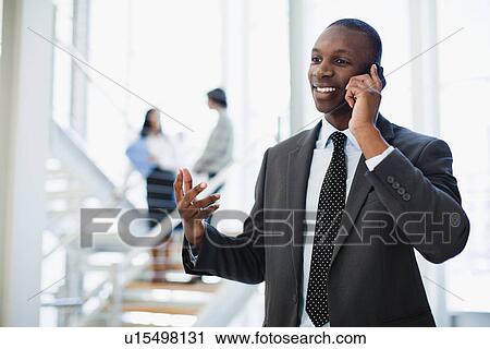 Businessman on cell phone in office View Large Photo Image Stock Image - Businessman on cell phone in office. Fotosearch
