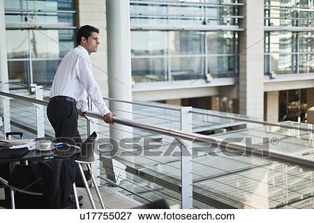 Stock Photo - Businessman on indoor balcony. Fotosearch