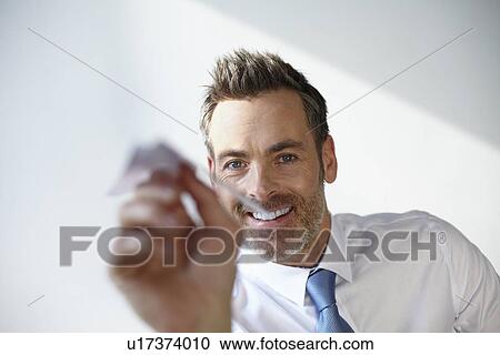 Stock Image - Businessman playing with paper airplane. Fotosearch