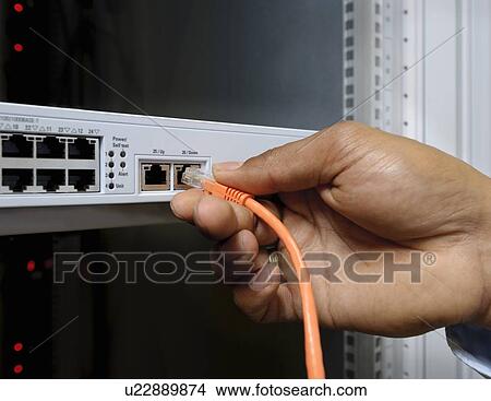 Businessman plugging cord into server View Large Photo Image Picture - Businessman plugging cord into server. Fotosearch