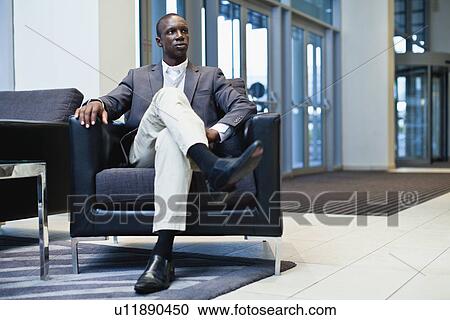 Stock Image - Businessman sitting in armchair. Fotosearch
