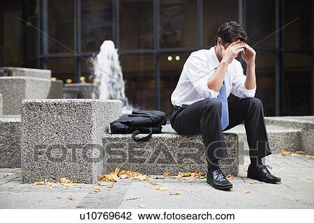Businessman sitting on urban fountain View Large Photo Image Stock Image - Businessman sitting on urban fountain. Fotosearch