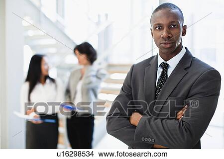 Businessman standing in office View Large Photo Image Picture - Businessman standing in office. Fotosearch