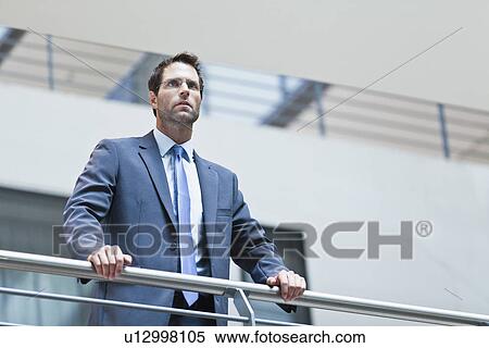 Businessman standing on balcony View Large Photo Image Stock Photography - Businessman standing on balcony. Fotosearch