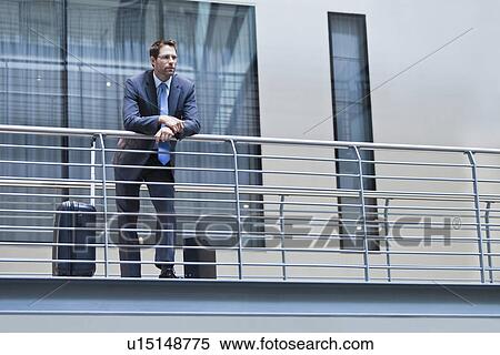Businessman standing on balcony View Large Photo Image Stock Photography - Businessman standing on balcony. Fotosearch