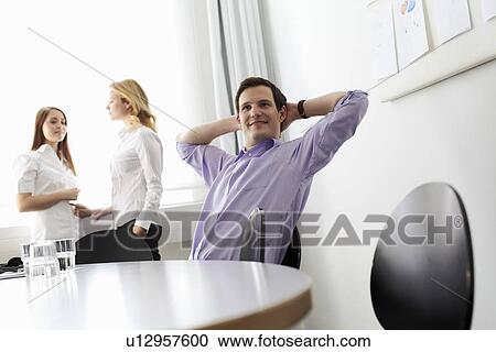 Businessman stretching in office View Large Photo Image Stock Image - Businessman stretching in office. Fotosearch