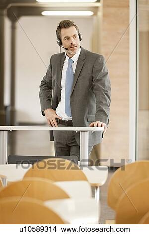 Businessman wearing headset at podium View Large Photo Image Picture - Businessman wearing headset at podium. Fotosearch