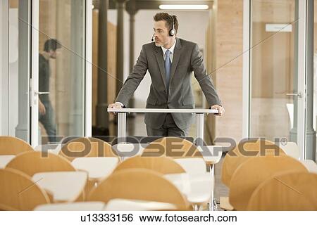 Businessman wearing headset at podium View Large Photo Image Stock Photograph - Businessman wearing headset at podium. Fotosearch