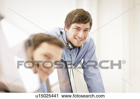 Businessman wearing headset in office View Large Photo Image Stock Image - Businessman wearing headset in office. Fotosearch